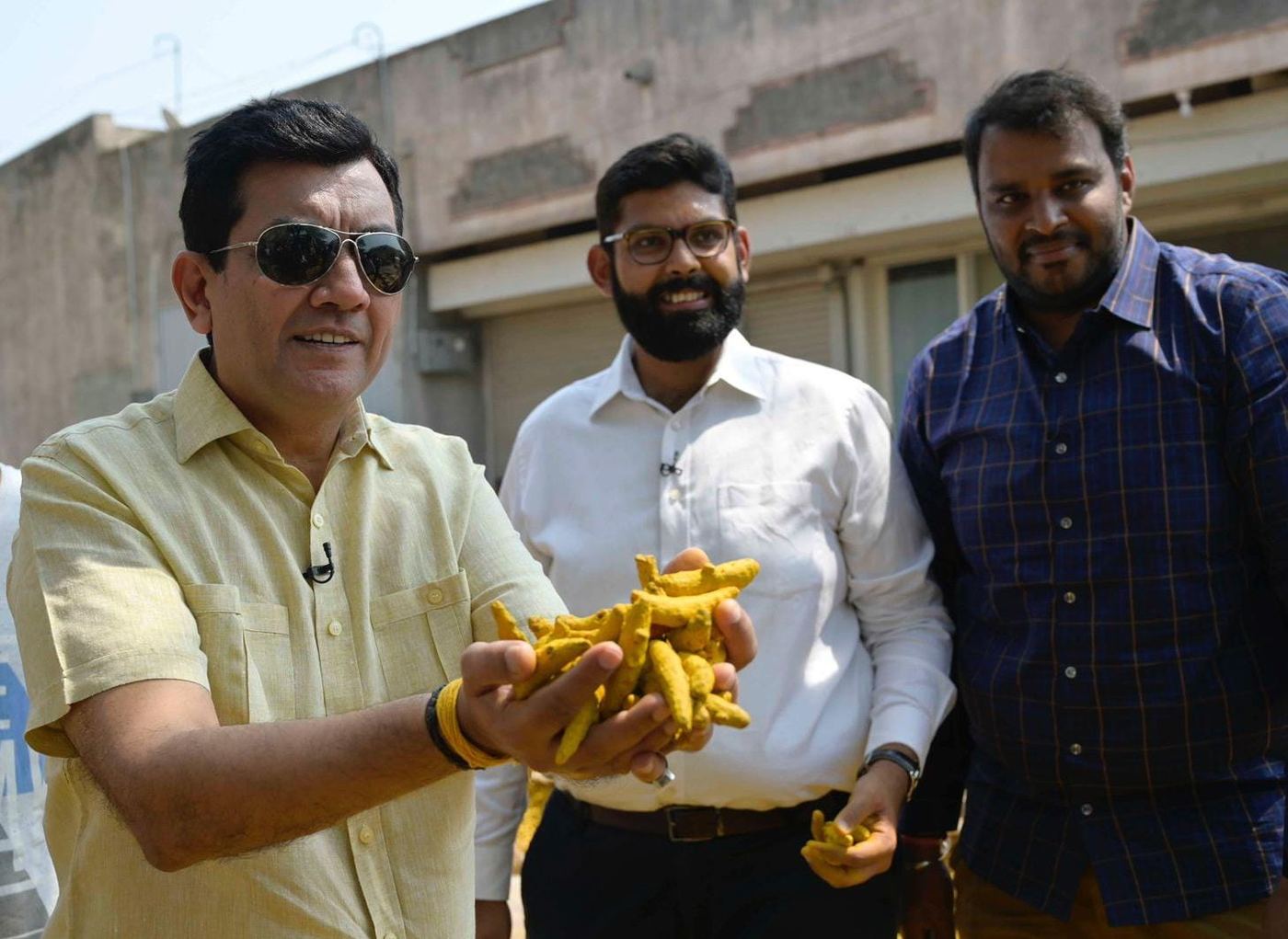 RK leadership meeting a supplier, inspecting fresh turmeric fingers in hand